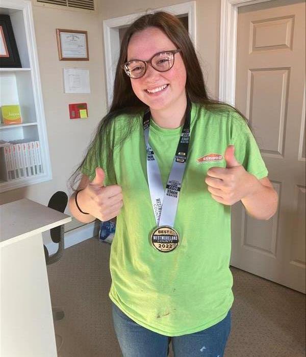 SERVPRO GBG tech Hailey wearing carpet cleaning medal